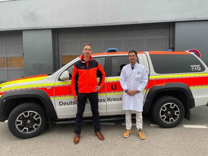 Dr. Benedikt Schick mit Prof. Carlos Schönfeldt-Lecuona vor einem Notarztwagen