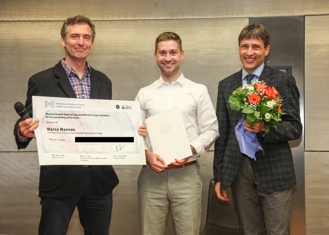 Picture of Prof. Knöll, Marco Mannes and Prof. Huber-Lang handing over the award